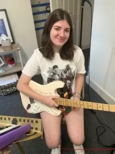 Image of a student with her guitar