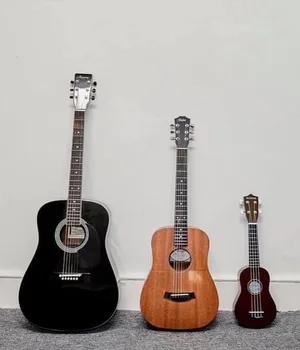A full-size acoustic guitar, a smaller travel-size guitar and a ukulele side by side, showing guitar sizes for kids