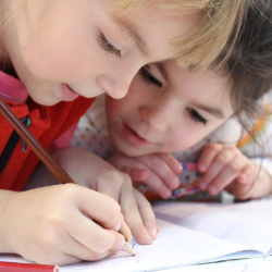 Image of two students writing in a notebook