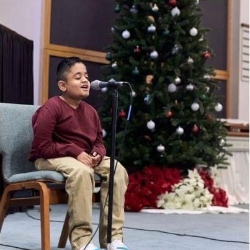 Image of a student singing at a recital
