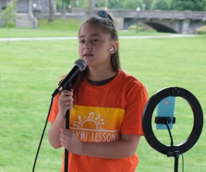 Image of a student singing at an outdoor recital