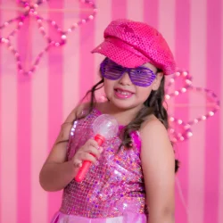 A young girl dressed as a pop star holding a microphone